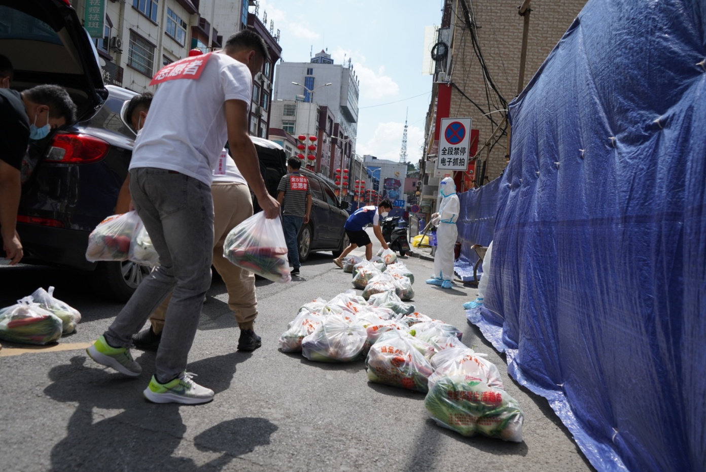 金沙縣鼓場街道的匯金大廈小區(qū)工作人員正在為居民送蔬菜包。