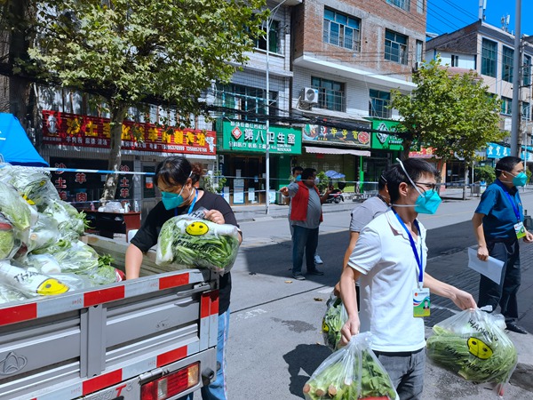 社區(qū)工作人員正在卸蔬菜包