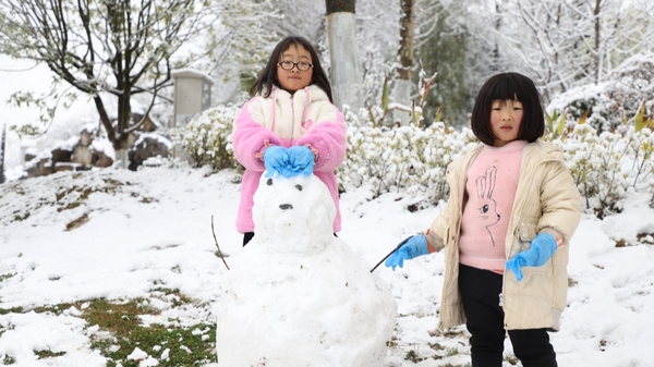 小朋友開(kāi)心的玩著堆著雪人 伍維玉 攝.jpg