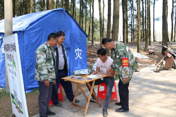 護(hù)林員指導(dǎo)進(jìn)山人員作登記。