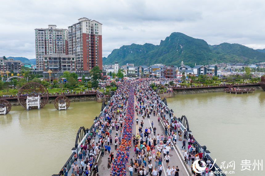 航拍身著民族盛裝巡游的少數(shù)民族同胞。人民網(wǎng)記者 涂敏攝