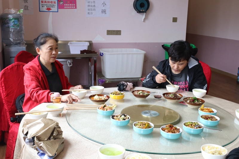 (2)社區(qū)老人們一起分享社區(qū)食堂美味的菜肴 劉麟 攝