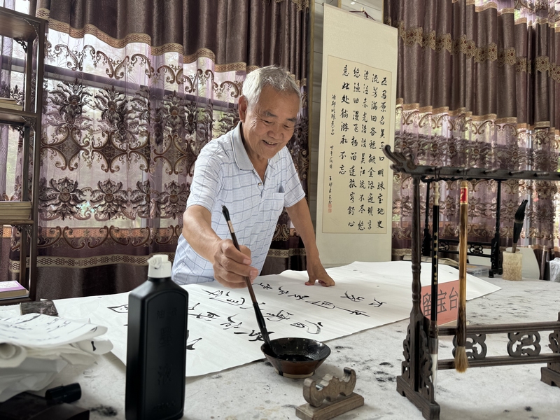 2、居民楊茂元在五馬鎮(zhèn)街道社區(qū)養(yǎng)老服務站練書法。