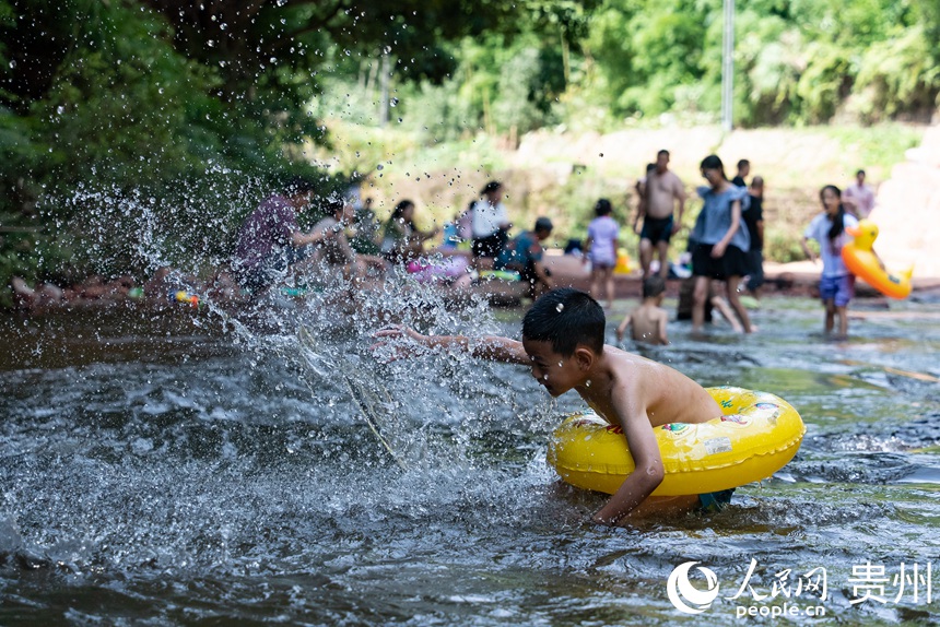 小朋友在瑪瑙灘內(nèi)打水仗。人民網(wǎng)記者 涂敏攝