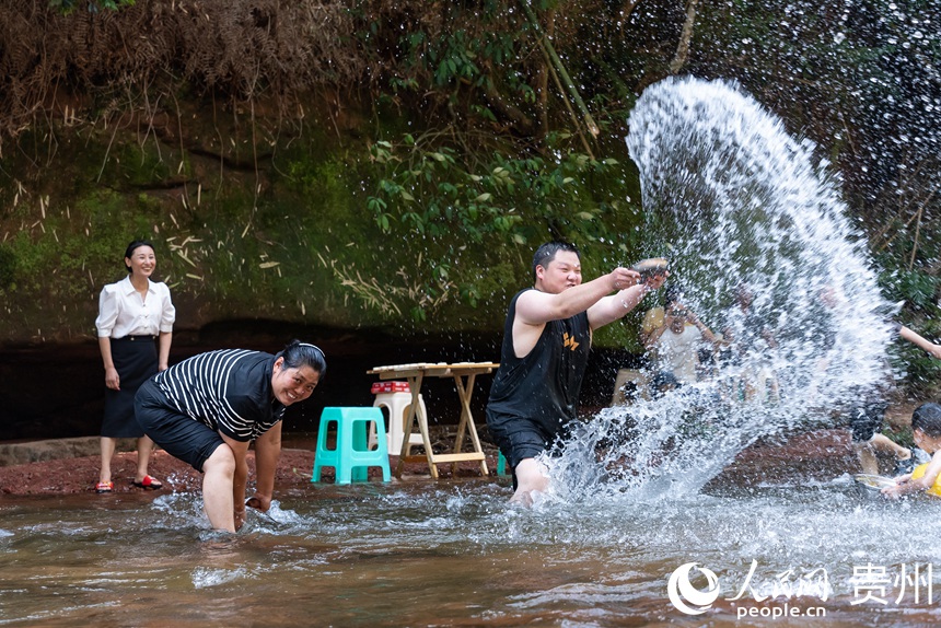 游客在瑪瑙灘內(nèi)打水仗。人民網(wǎng)記者 涂敏攝